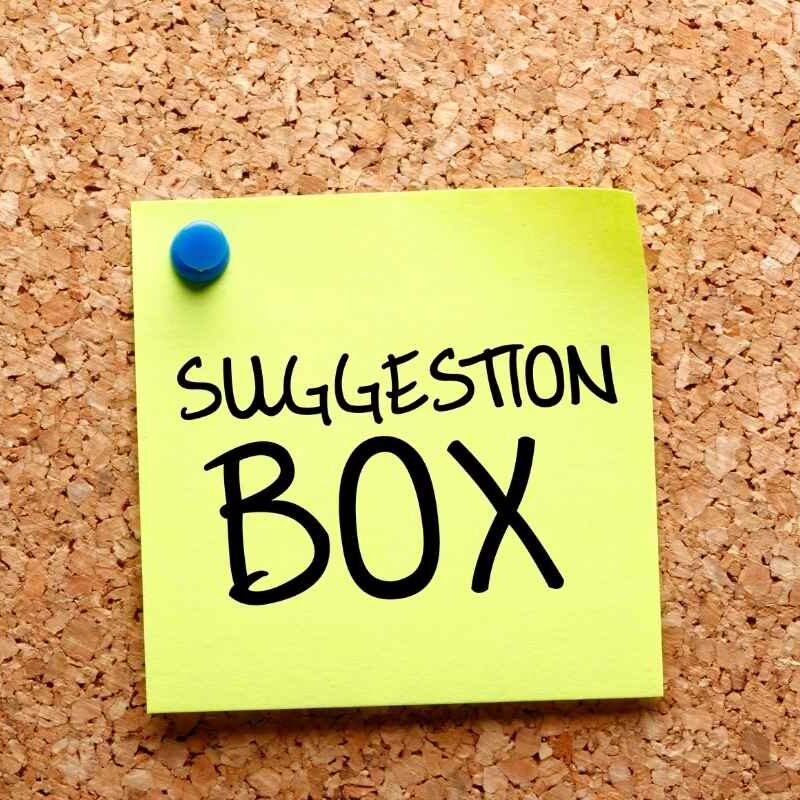 boite-a-suggestions Post-it sur un tableau en liège avec écrit "Boite à suggestions" dessus