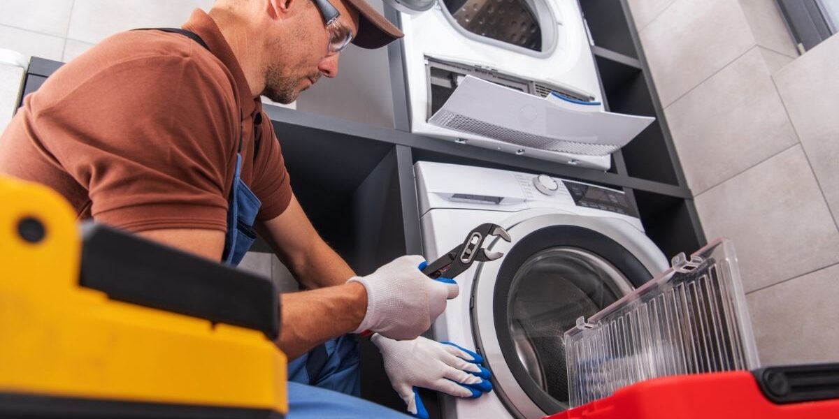 Homme en train de réparer une machine à lessiver